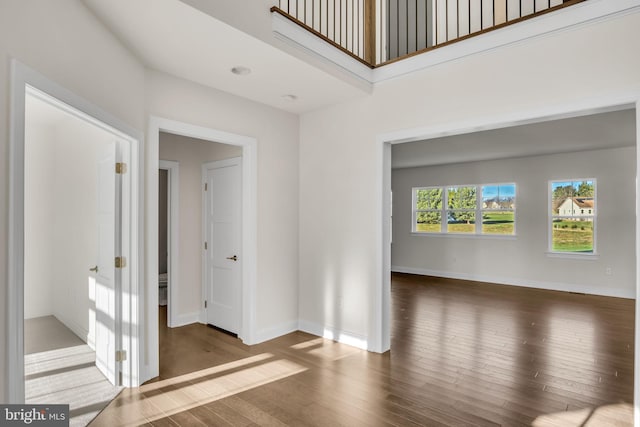 unfurnished room with dark hardwood / wood-style floors and a high ceiling