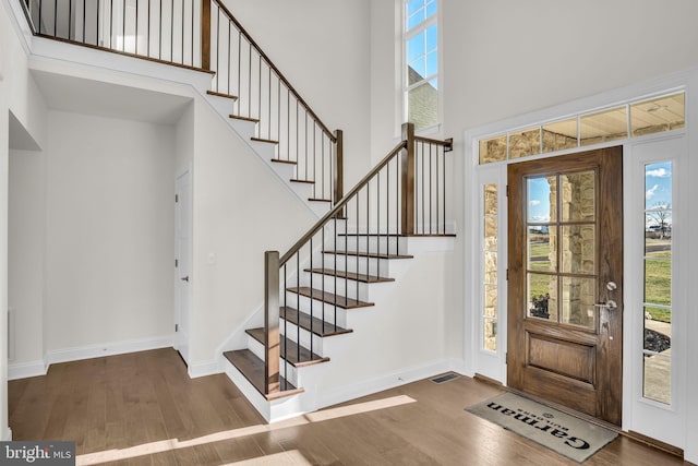 foyer with dark wood-type flooring and a high ceiling