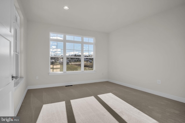 unfurnished room with dark carpet