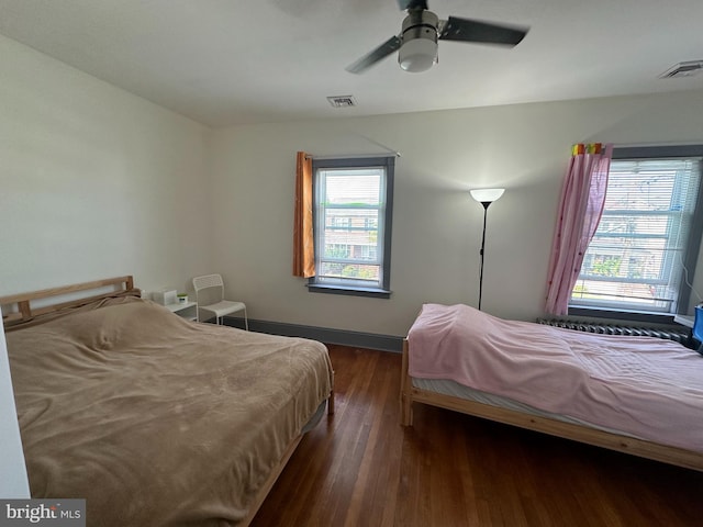 bedroom with ceiling fan and dark wood-type flooring