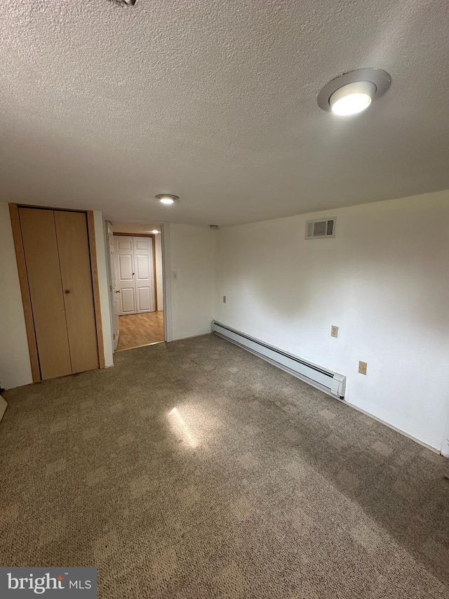 interior space featuring a textured ceiling, carpet flooring, and baseboard heating