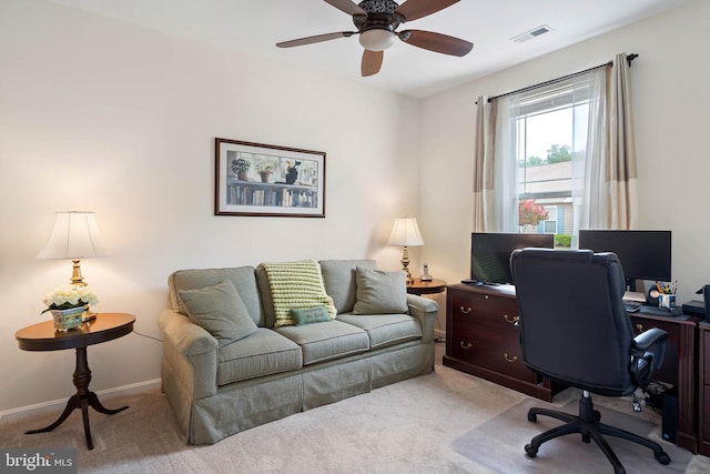 carpeted home office featuring ceiling fan