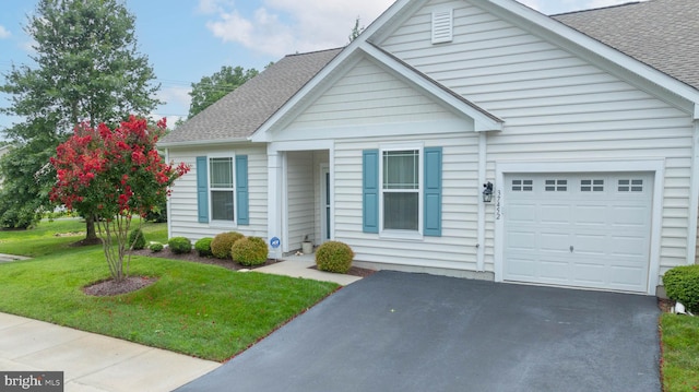 view of front of property featuring a front yard and a garage