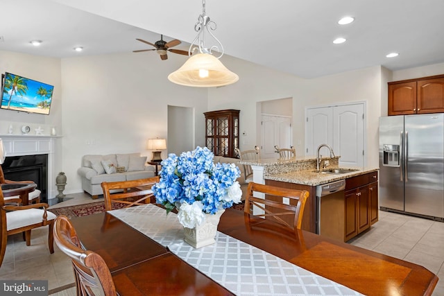 dining area with ceiling fan, light tile patterned floors, and sink