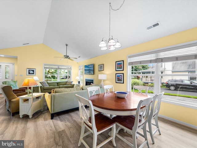 dining space featuring lofted ceiling, a healthy amount of sunlight, and light wood-type flooring