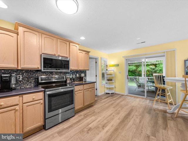 kitchen featuring light brown cabinetry, decorative backsplash, and appliances with stainless steel finishes