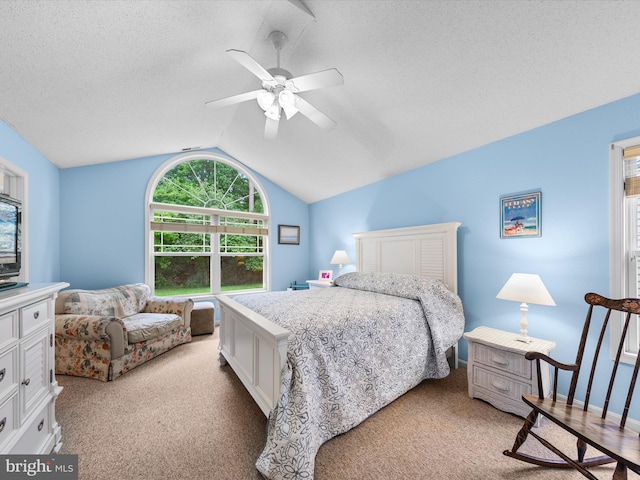 carpeted bedroom featuring vaulted ceiling, ceiling fan, and a textured ceiling