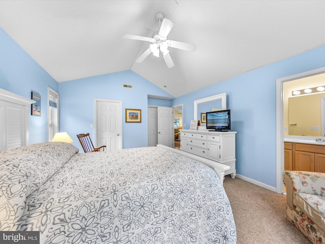 carpeted bedroom featuring ensuite bathroom, sink, vaulted ceiling, a closet, and ceiling fan