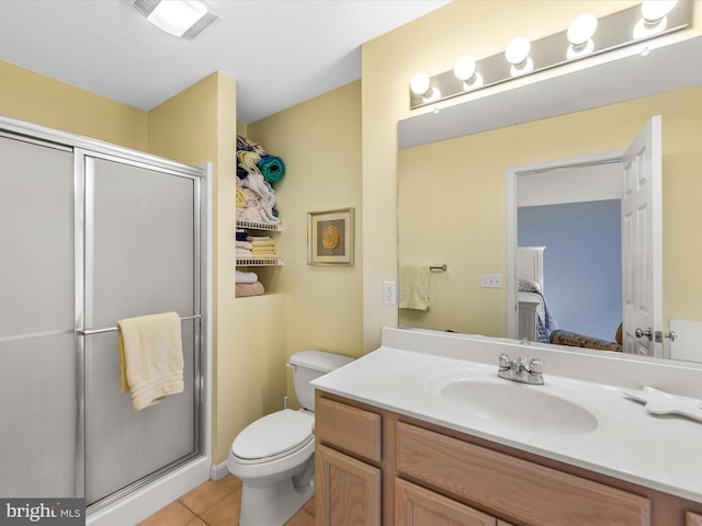 bathroom with an enclosed shower, toilet, vanity, and tile patterned flooring