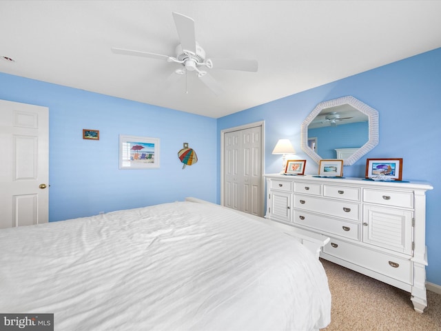 bedroom featuring ceiling fan, light colored carpet, and a closet