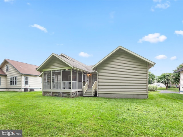 back of property with central AC unit, a sunroom, and a lawn