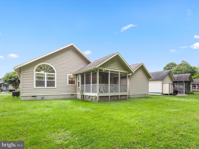 rear view of house with central air condition unit, a sunroom, and a yard