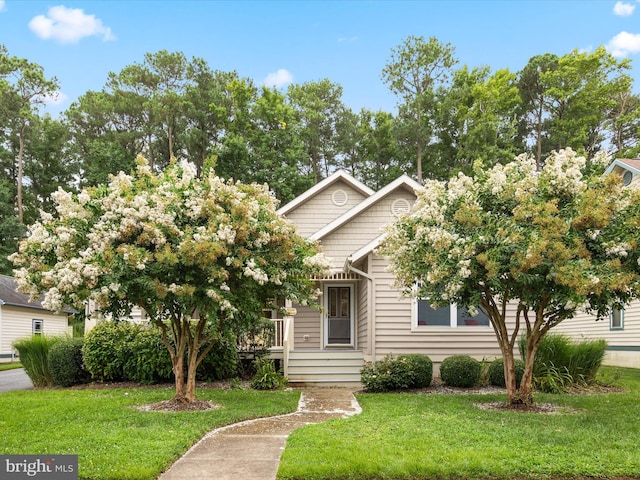 view of property hidden behind natural elements featuring a front lawn