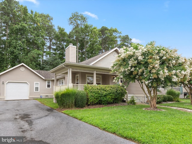 view of front facade with a front lawn, covered porch, and a garage