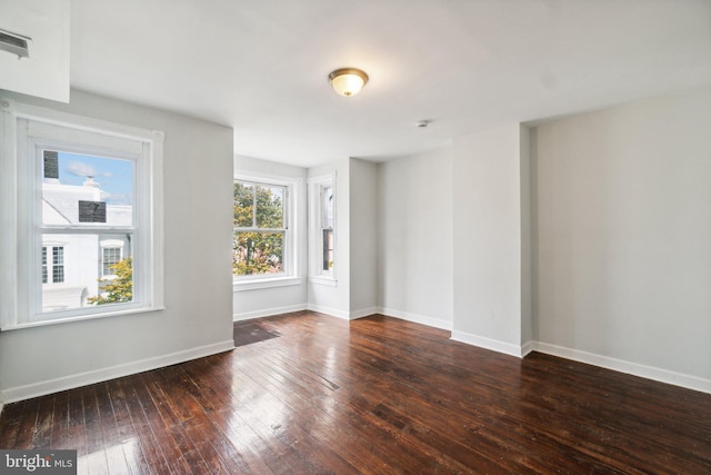 unfurnished room with dark hardwood / wood-style flooring