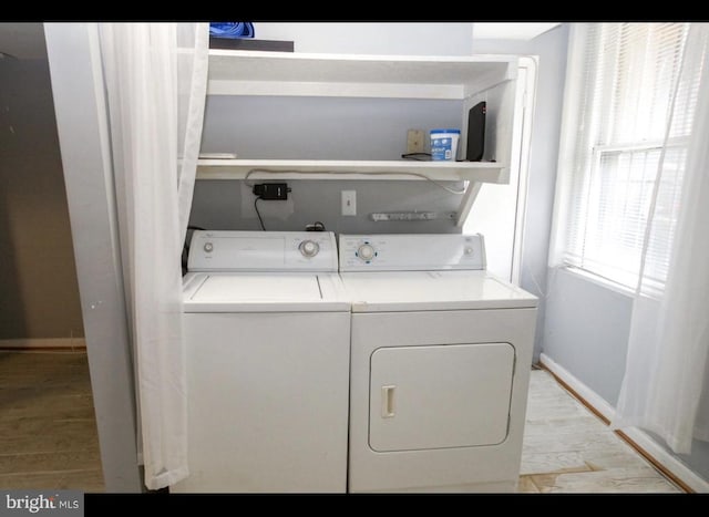 clothes washing area featuring light hardwood / wood-style floors and washing machine and dryer