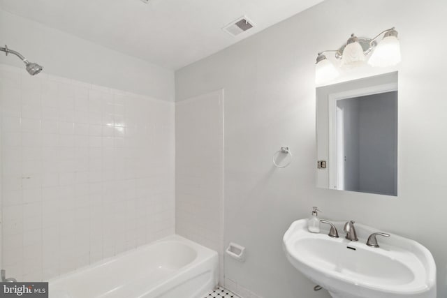 bathroom with tiled shower / bath, sink, and tile patterned flooring