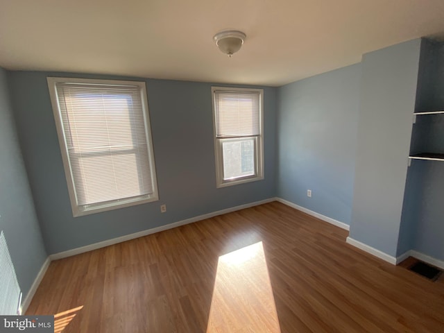 spare room featuring wood-type flooring