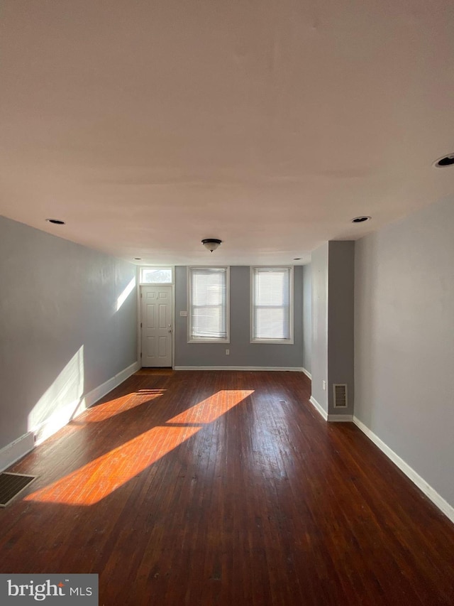 unfurnished room with dark wood-type flooring