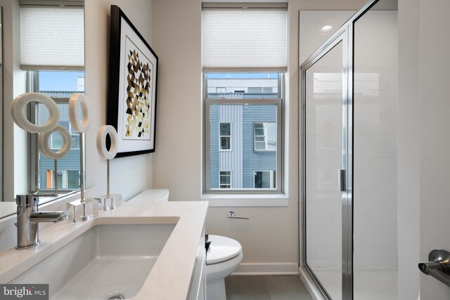 bathroom featuring a shower with door, vanity, tile patterned floors, and toilet