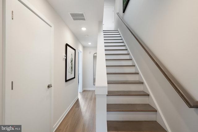 staircase with hardwood / wood-style flooring