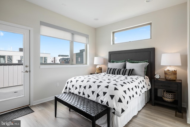 bedroom with multiple windows and light hardwood / wood-style floors