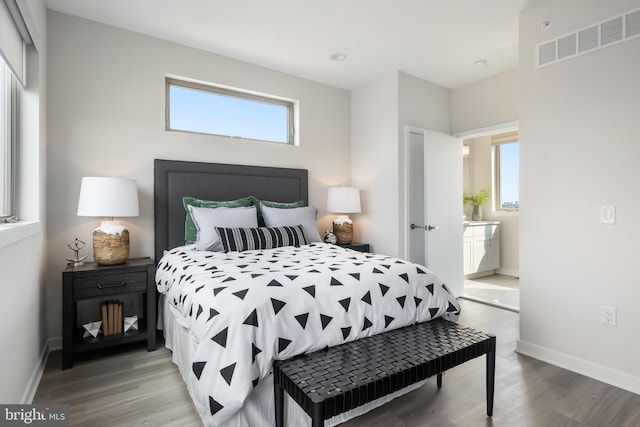 bedroom featuring hardwood / wood-style floors and multiple windows