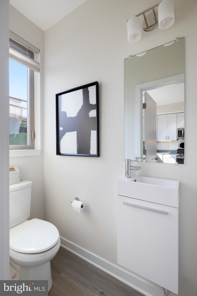 bathroom featuring vanity, toilet, and hardwood / wood-style floors