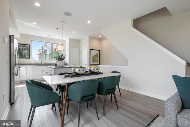 dining space featuring light hardwood / wood-style flooring and sink