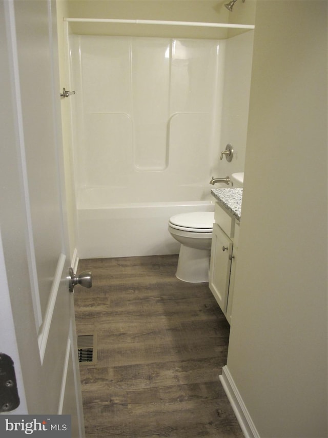 full bathroom featuring shower / bathing tub combination, wood-type flooring, vanity, and toilet