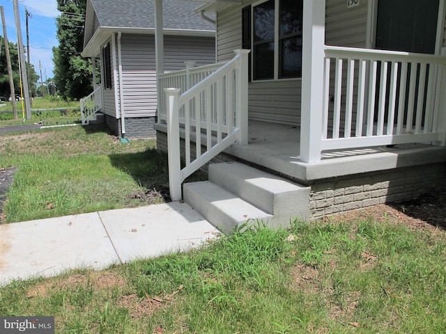 view of exterior entry with a yard and a wooden deck