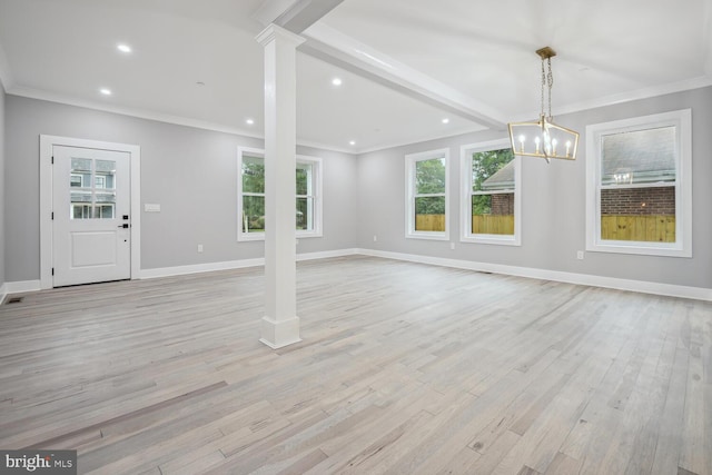 unfurnished living room featuring light hardwood / wood-style flooring, a wealth of natural light, ornate columns, and crown molding