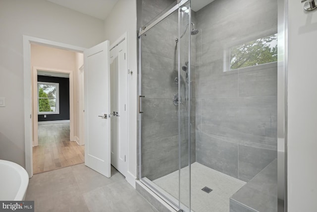 bathroom with wood-type flooring and separate shower and tub