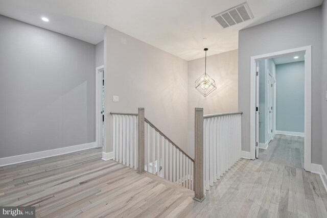 staircase featuring hardwood / wood-style flooring and a chandelier