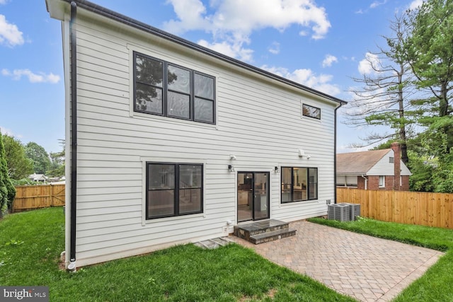 rear view of property featuring central AC, a yard, and a patio area