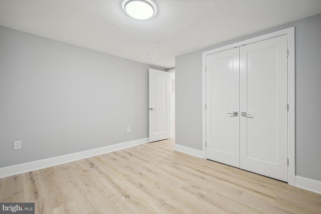 unfurnished bedroom with light hardwood / wood-style flooring and a closet