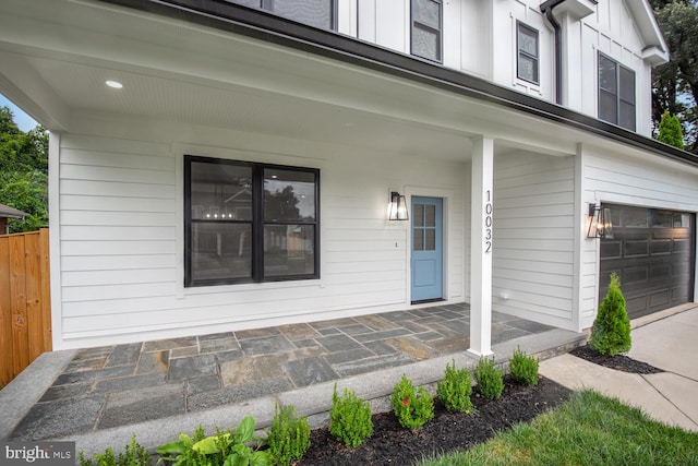 entrance to property featuring a garage and a porch