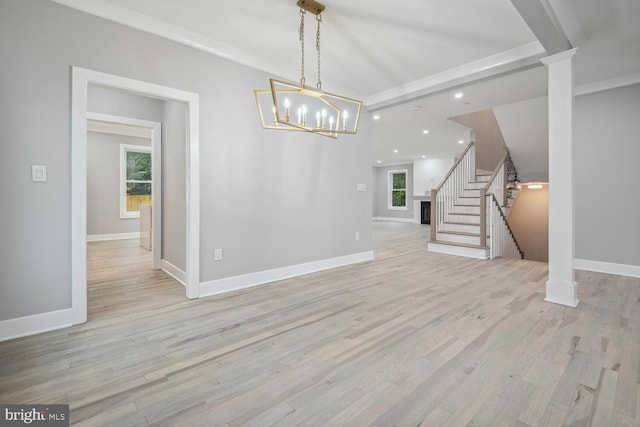 unfurnished dining area featuring light hardwood / wood-style flooring, decorative columns, and a healthy amount of sunlight