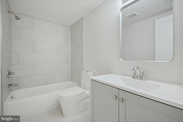 full bathroom featuring tile patterned floors, vanity, tiled shower / bath, and toilet