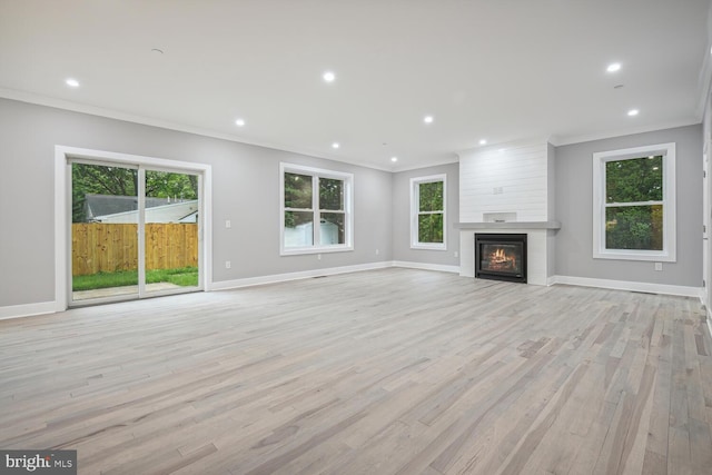 unfurnished living room featuring a large fireplace, light hardwood / wood-style floors, and crown molding