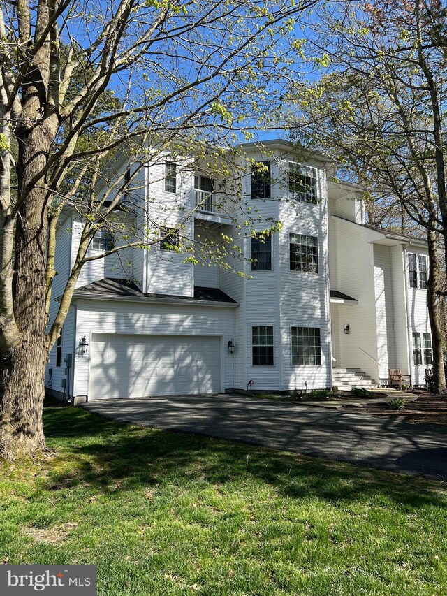 view of front of home with a front yard and a garage