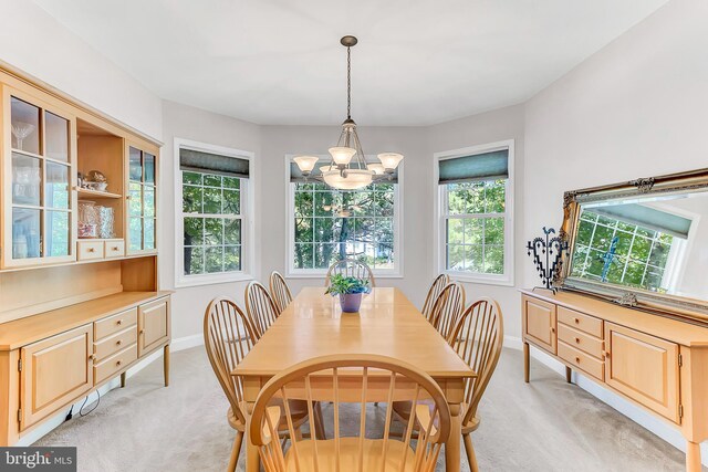 carpeted dining space with a chandelier