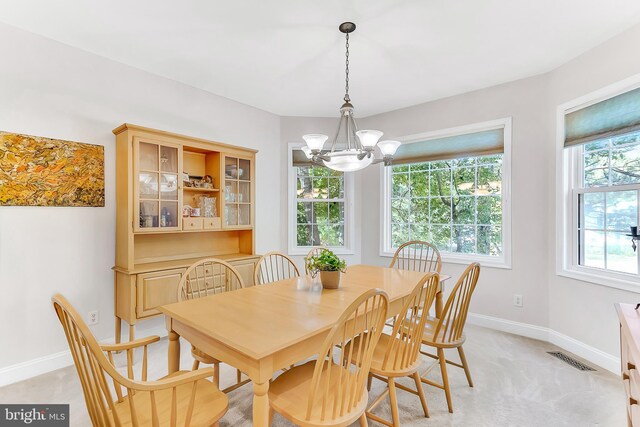 carpeted dining room with a chandelier