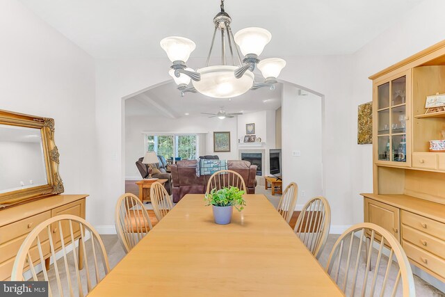 carpeted dining area with ceiling fan with notable chandelier