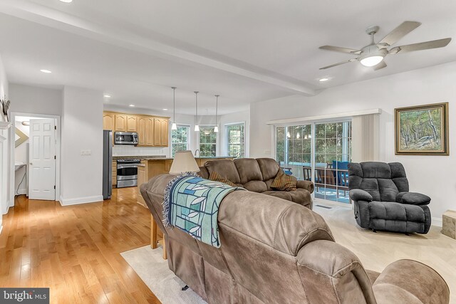 living room featuring ceiling fan, light hardwood / wood-style floors, and beam ceiling