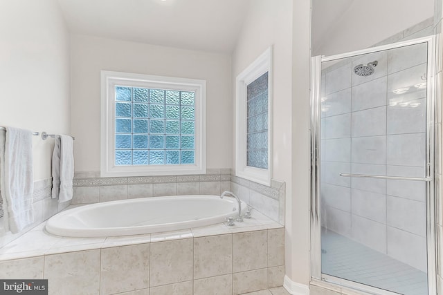 bathroom featuring lofted ceiling and independent shower and bath