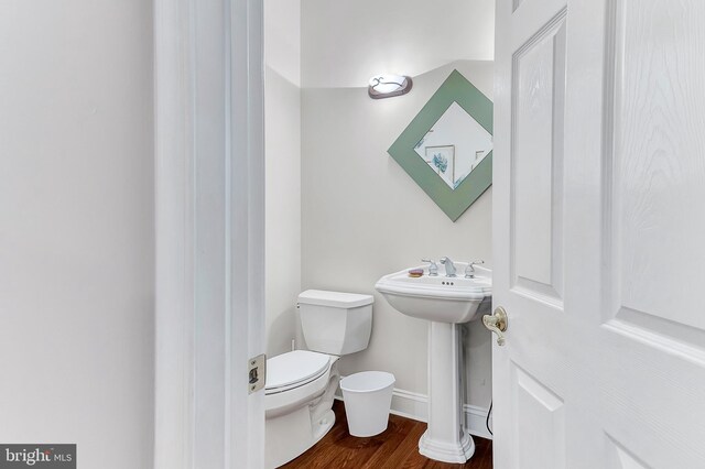 bathroom featuring toilet, wood-type flooring, and sink