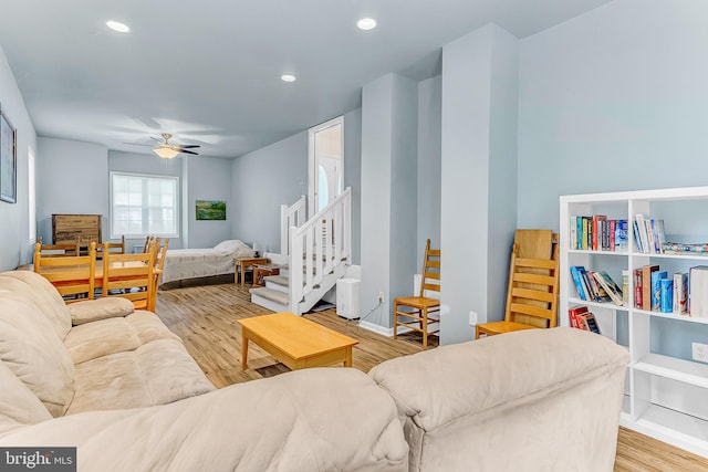 living room with light hardwood / wood-style flooring and ceiling fan