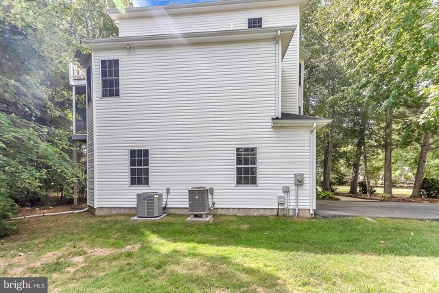 exterior space featuring cooling unit and a lawn