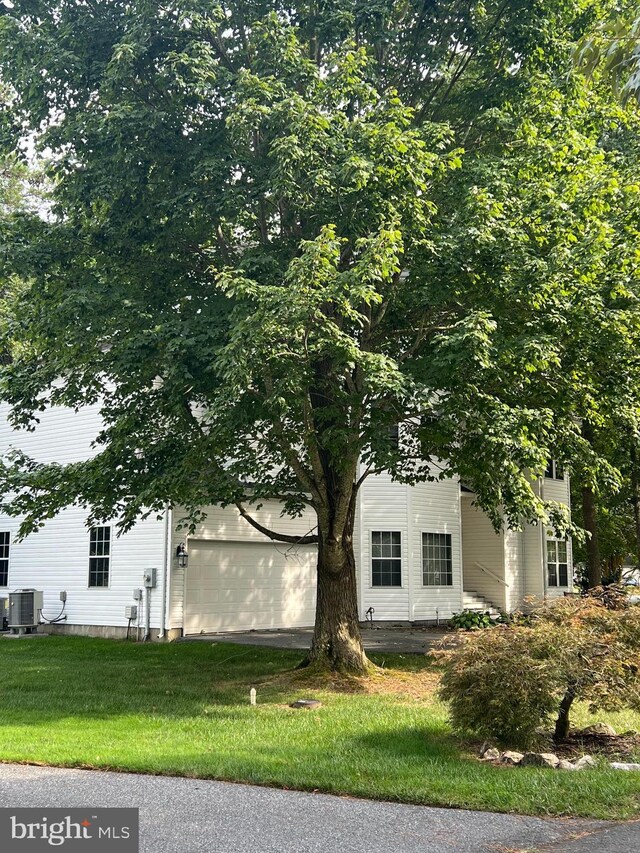 view of front facade featuring a front lawn and cooling unit